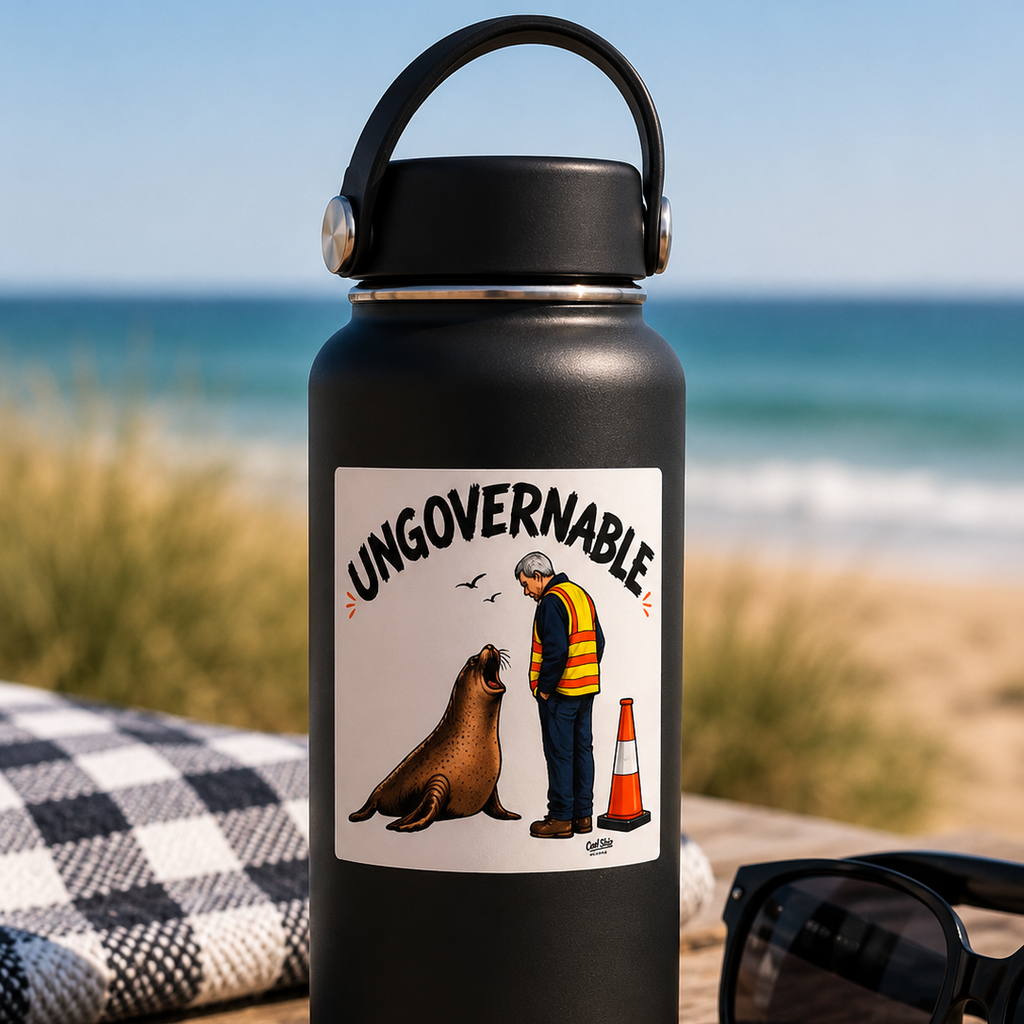 A matte black insulated water bottle standing on a beach table. The bottle has a Cool Shiz Neil the seal Ungovernable Waterproof, Scratch Resistant, Vinyl Sticker on it.